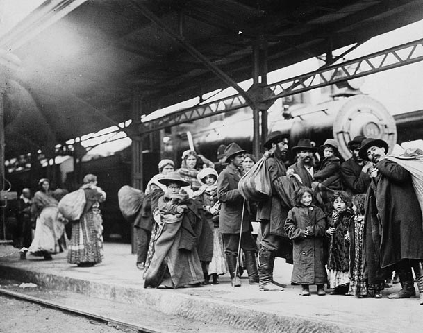 A group of immigrant families with bundles and luggage on the platform at Union Station, Toronto, around 1910