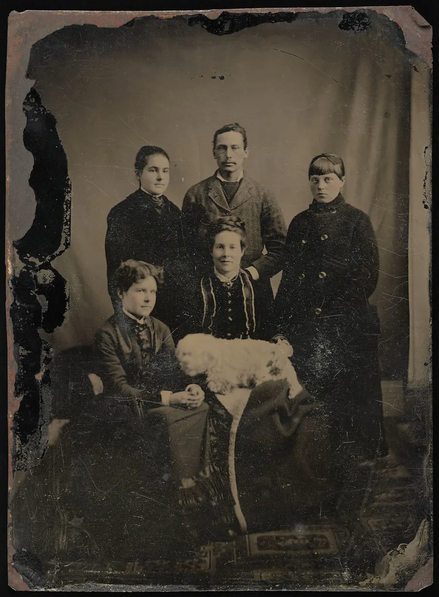 Tintype studio portrait of a Victorian-era family of five (two seated women, a standing man, and two children), ca. late 19th century.