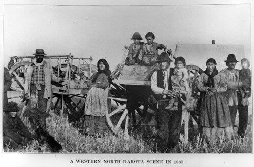 A Métis family photographed with Red River carts in 1883, the era whose scrip and parish records underpin Métis ancestry research in Saskatchewan